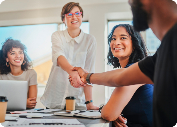 Professionals welcoming a colleague with a handshake